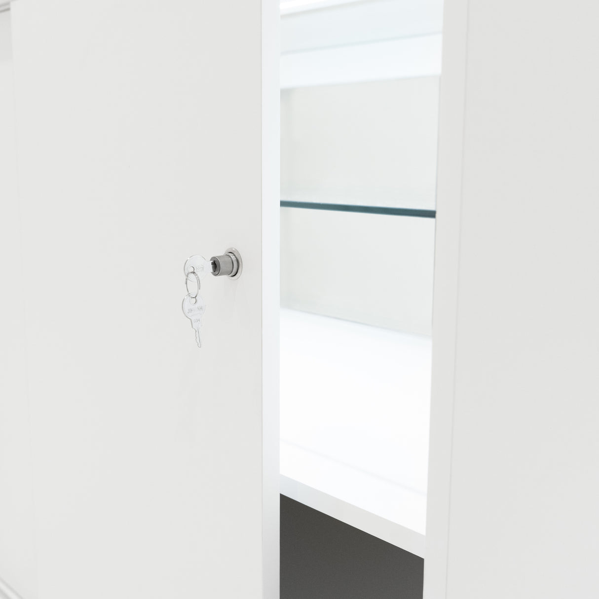 Weiße LED-Ladentheke mit glatter Oberfläche, transparenten Regalen und einem Schlüssel, der in das Schloss der Tür steckt