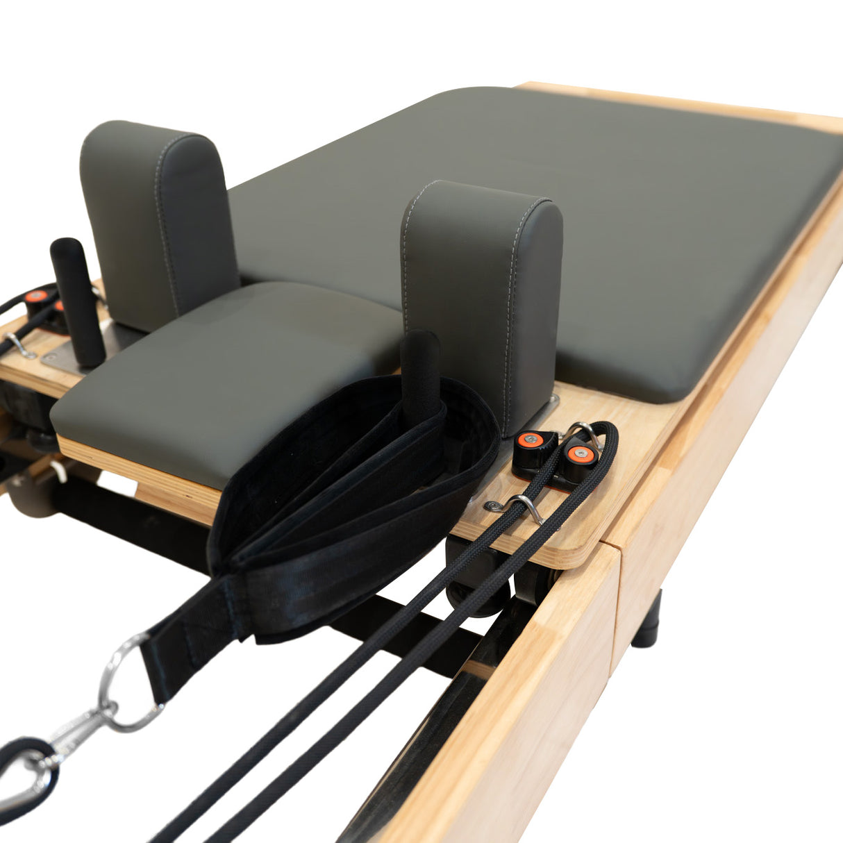 Pilates Reformer Maschine aus Eiche mit grauem Polster, gepolsterten Kopfstützen und verstellbaren Widerstandsbändern für vielseitiges Training