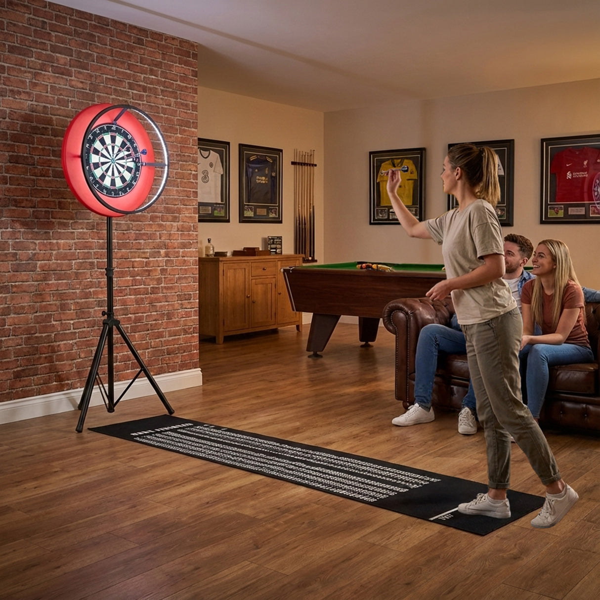 Dartspielende Frau vor einem beleuchteten Dartboard mit rotem LED-Ringlicht, umgeben von Freunden in einem gemütlichen Raum mit Holzfußboden