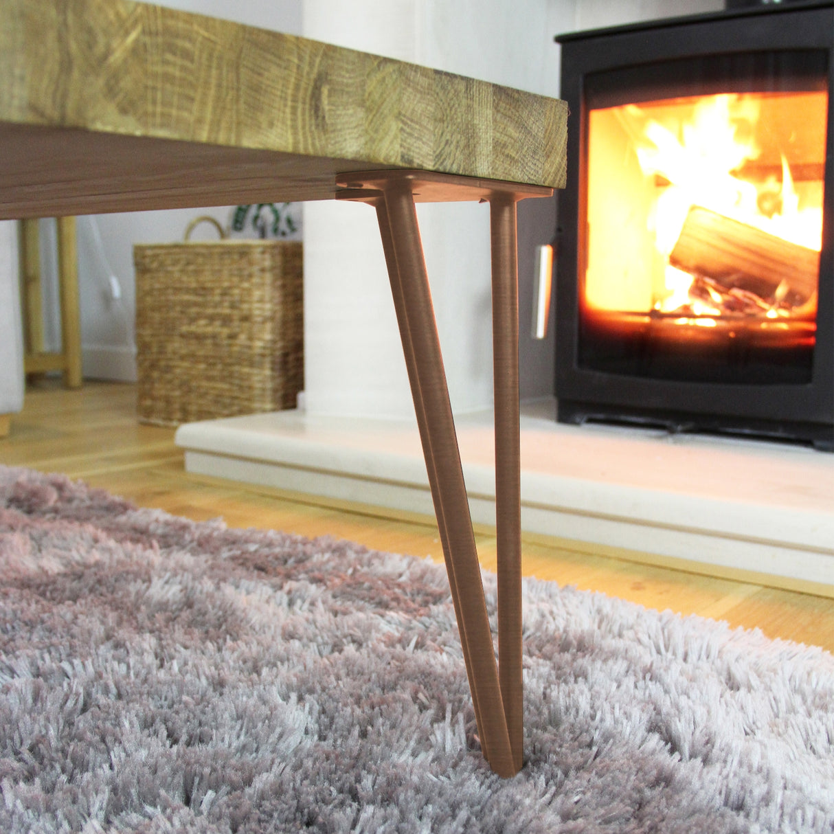 Kupferne Hairpin Tischbeine mit zwei Streben, 71 cm hoch, elegant geformt, perfekt für rustikale oder moderne Möbel, vor einem Kamin platziert