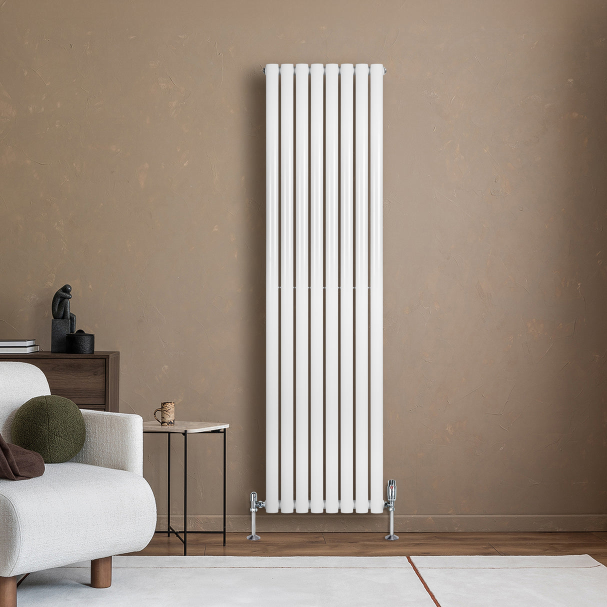 Hochformatiger, weißer Gliederheizkörper mit TRV Chromventilen, elegant an einer warmen Wand montiert, umgeben von modernem Möbelstück und Dekoration