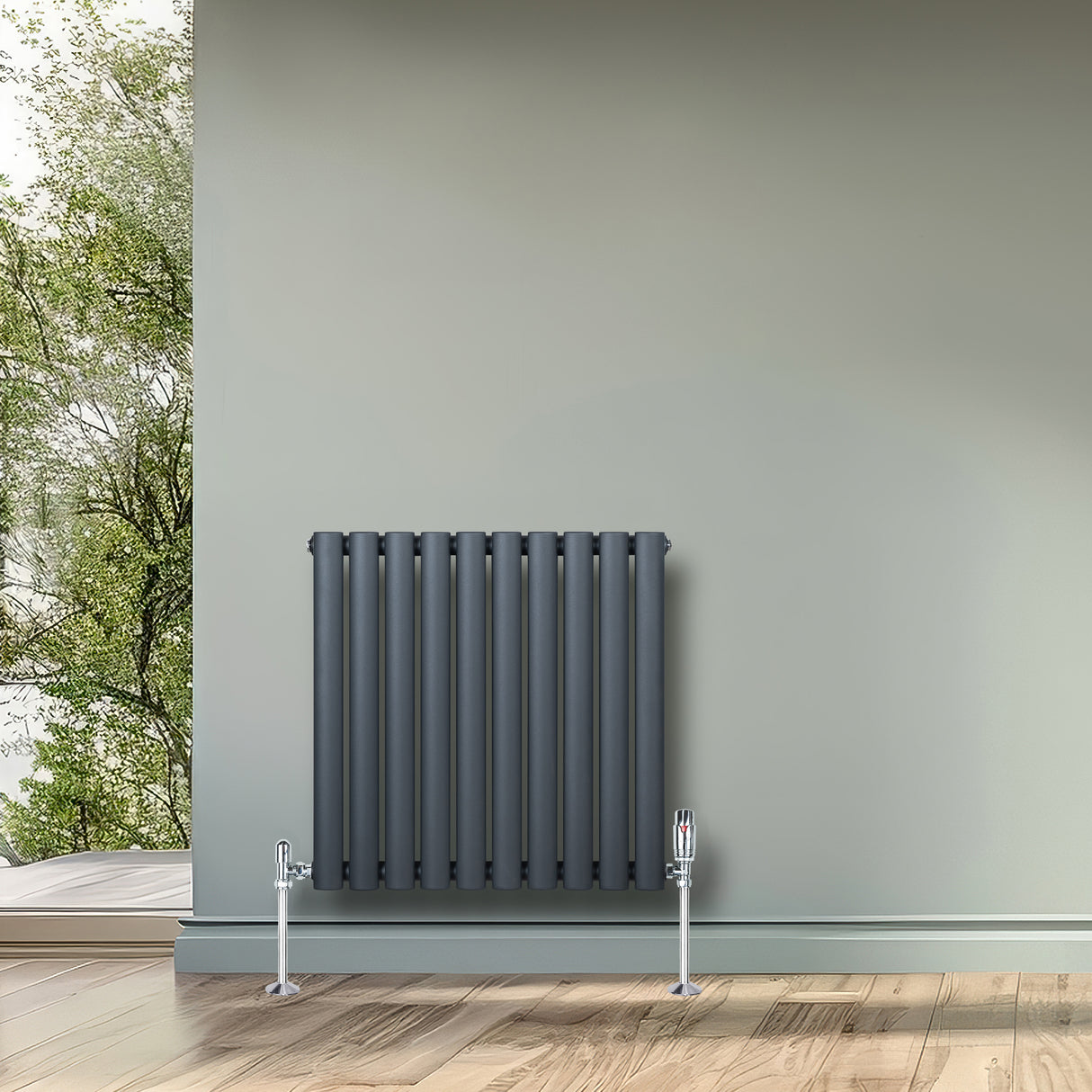 Anthrazitgrauer Gliederheizkörper mit TRV Chromventilen, 600mm x 600mm, an einer Wand, umgeben von natürlichem Licht und Holzfußboden