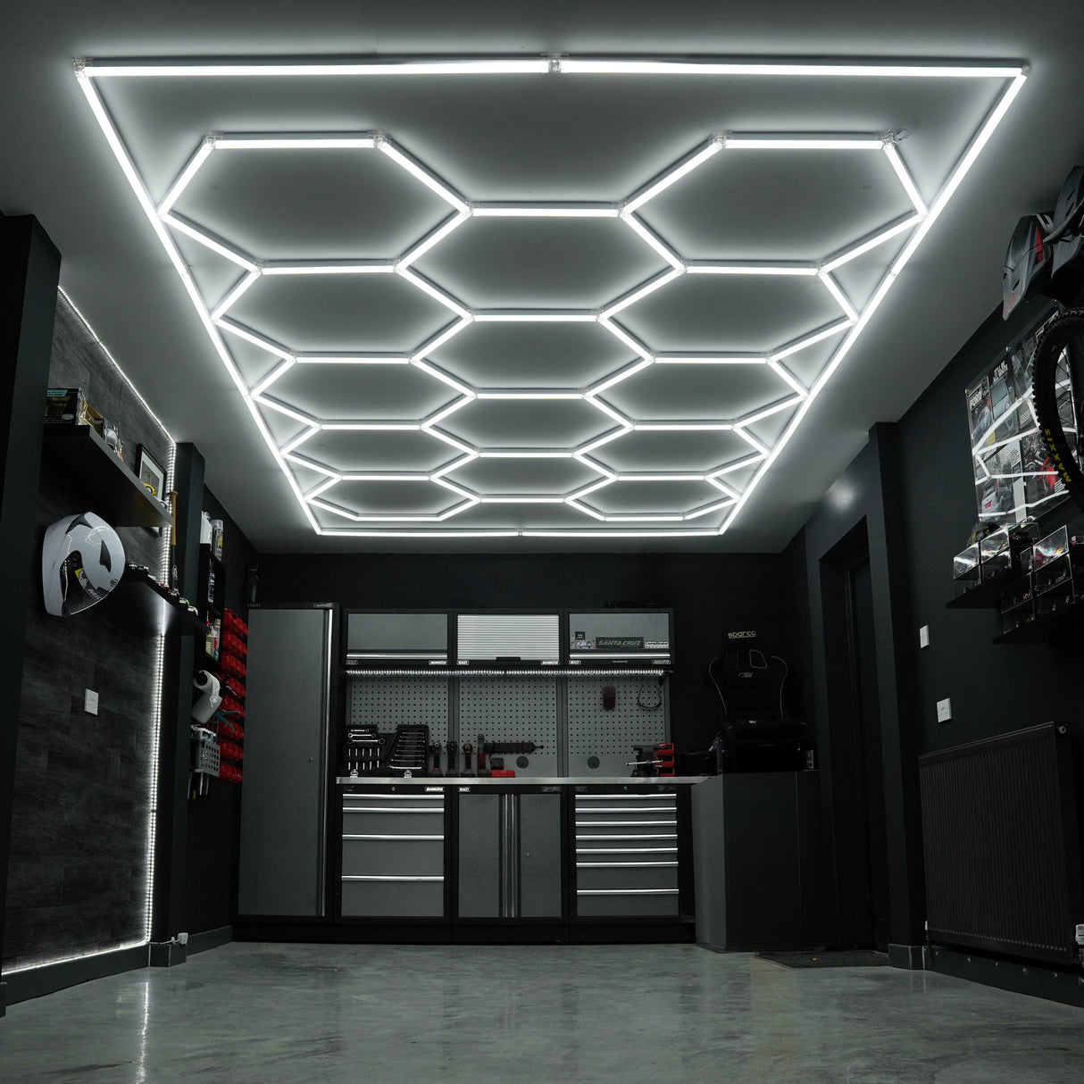 Belüftete Garagenbodenfliesen in Blau und sechseckige LED-Leuchten an der Decke schaffen eine moderne, stilvolle Atmosphäre im Garagenraum