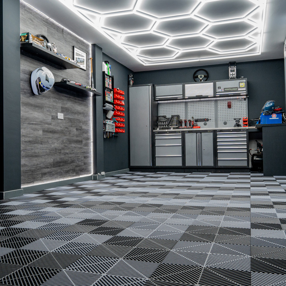 Sechseckige, belüftete Garagenbodenfliesen in Schwarz und Grau, mit Kantenschutz, auf einem modernen, strukturierten Boden in einer stilvollen Garage