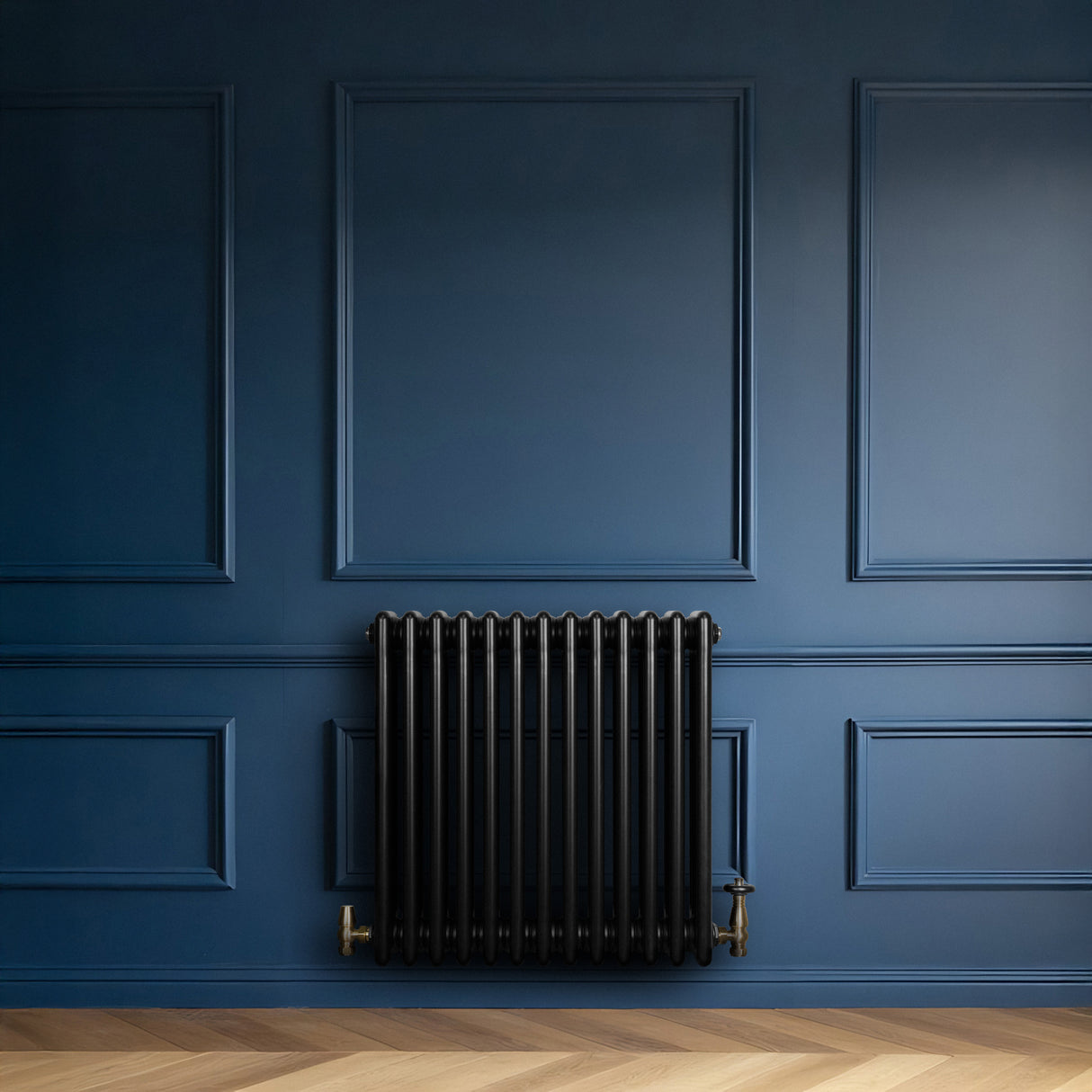Schwarzer Röhrenheizkörper mit vier Säulen, 600mm x 605mm, an einer blauen Wand, ergänzt durch einen eleganten, goldenen Wasserhahn