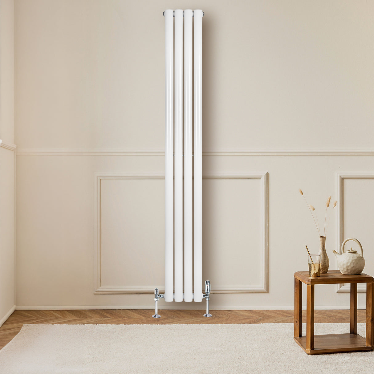 Hochformatiger, weißer Gliederheizkörper mit vier vertikalen Elementen, montiert an einer hellen Wand, vor einem minimalistischen Wohnraum mit Holzdetails