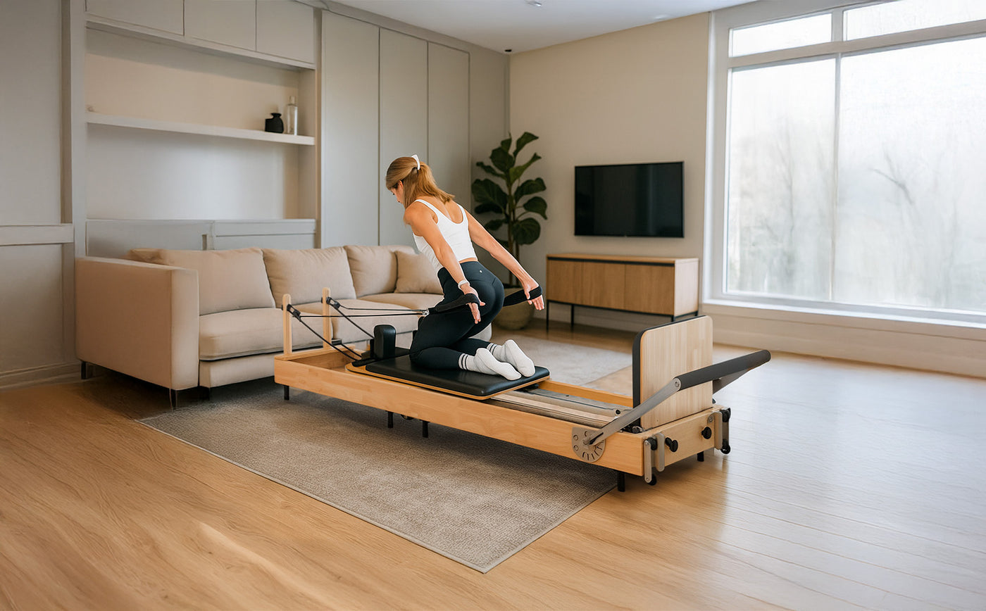 Frau in Sportkleidung trainiert auf einem Pilates-Reformer aus hellem Holz in einem modernen Wohnzimmer mit großen Fenstern und neutralen Farben