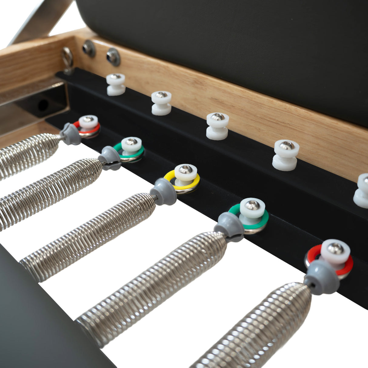 Pilates Reformer Maschine aus Eiche mit grauem Polster, verstellbaren Federn in verschiedenen Farben und robustem, modernem Design