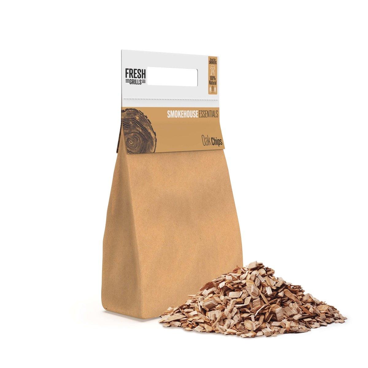 Braune Papiertüte mit Eichenholzchips, daneben ein Haufen feiner Holzspäne, ideal zum Räuchern von Fleisch und Gemüse beim Grillen