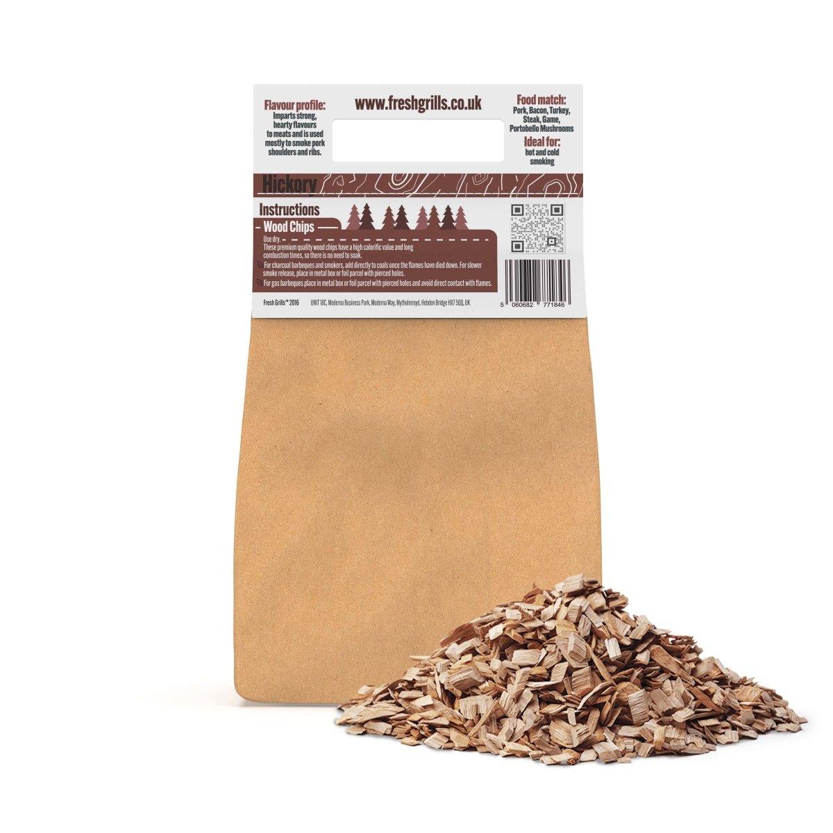 Hickory-Räucherholzstücke in einer braunen Verpackung, mit einer lockeren Ansammlung von kleinen, hellbraunen Holzstücken auf einem weißen Hintergrund