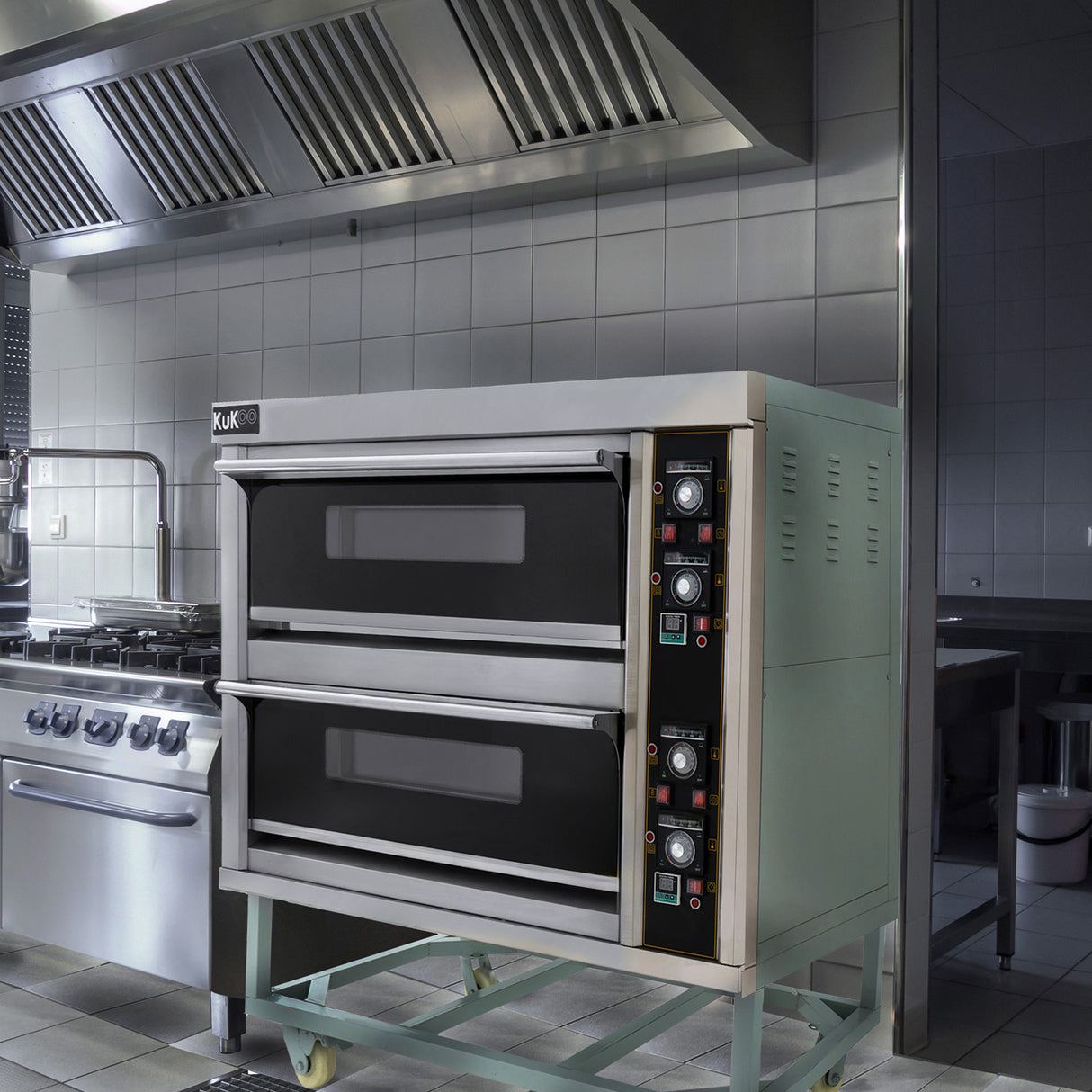 Großer gewerblicher KuKoo Pizza- und Backofen in Edelstahl mit zwei Backkammern, Bedienelementen und einem modernen, funktionalen Design in einer professionellen Küche