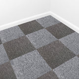 Teppichfliesen in Anthrazitgrau mit strukturiertem, weichem Material, in einem modernen, schachbrettartigen Muster verlegt, ideal für stilvolle Räume