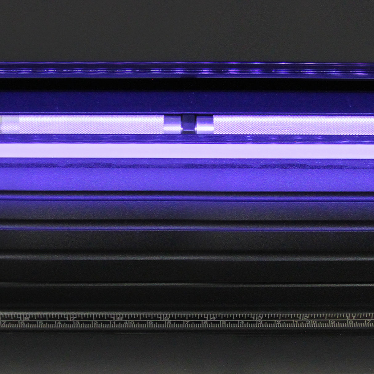 Der 720 Vinylschneider mit Ständer zeigt eine glänzende schwarze Oberfläche, eine LED-Lichtleiterleiste in lila und eine präzise Messskala aus Metall