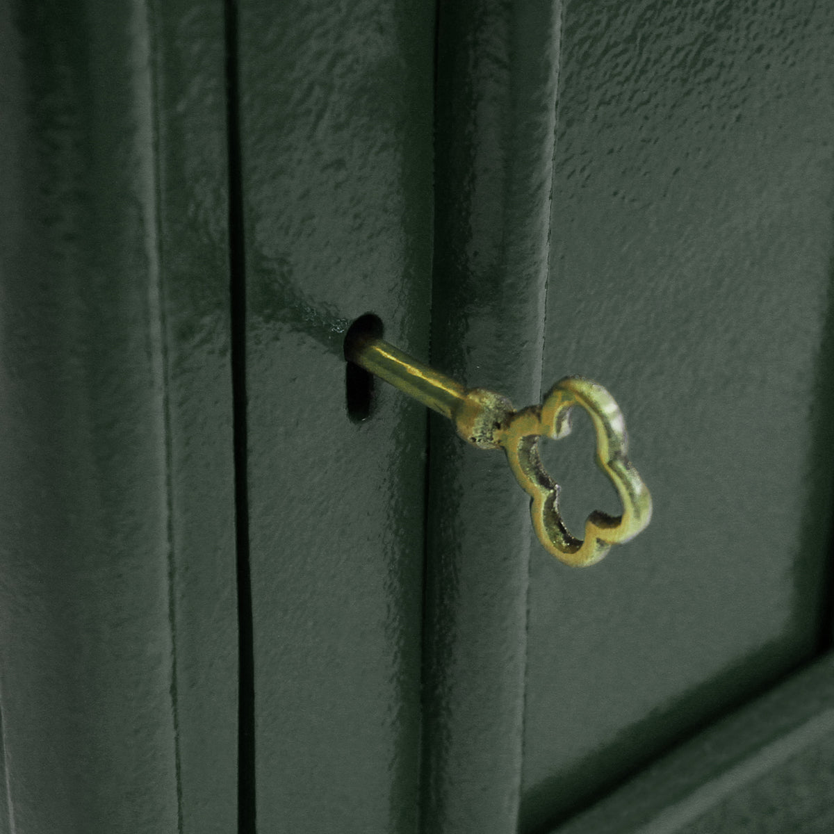 Grüner Briefkasten mit Bodenständer, aus robustem Metall, glänzender Oberfläche, dekorativer Schlüssel im Schloss sichtbar