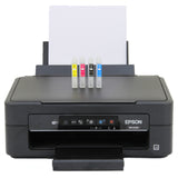 Schwarzer Epson-Drucker XP-2100 mit vier Tintenpatronen in Cyan, Magenta, Gelb und Schwarz, bereit für den Druck auf weißem Papier