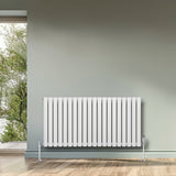 Gliederheizkörper in Weiß mit TRV Chromventilen, 600mm x 1200mm, elegant an einer Wand, umgeben von natürlichem Licht und Holzfußboden