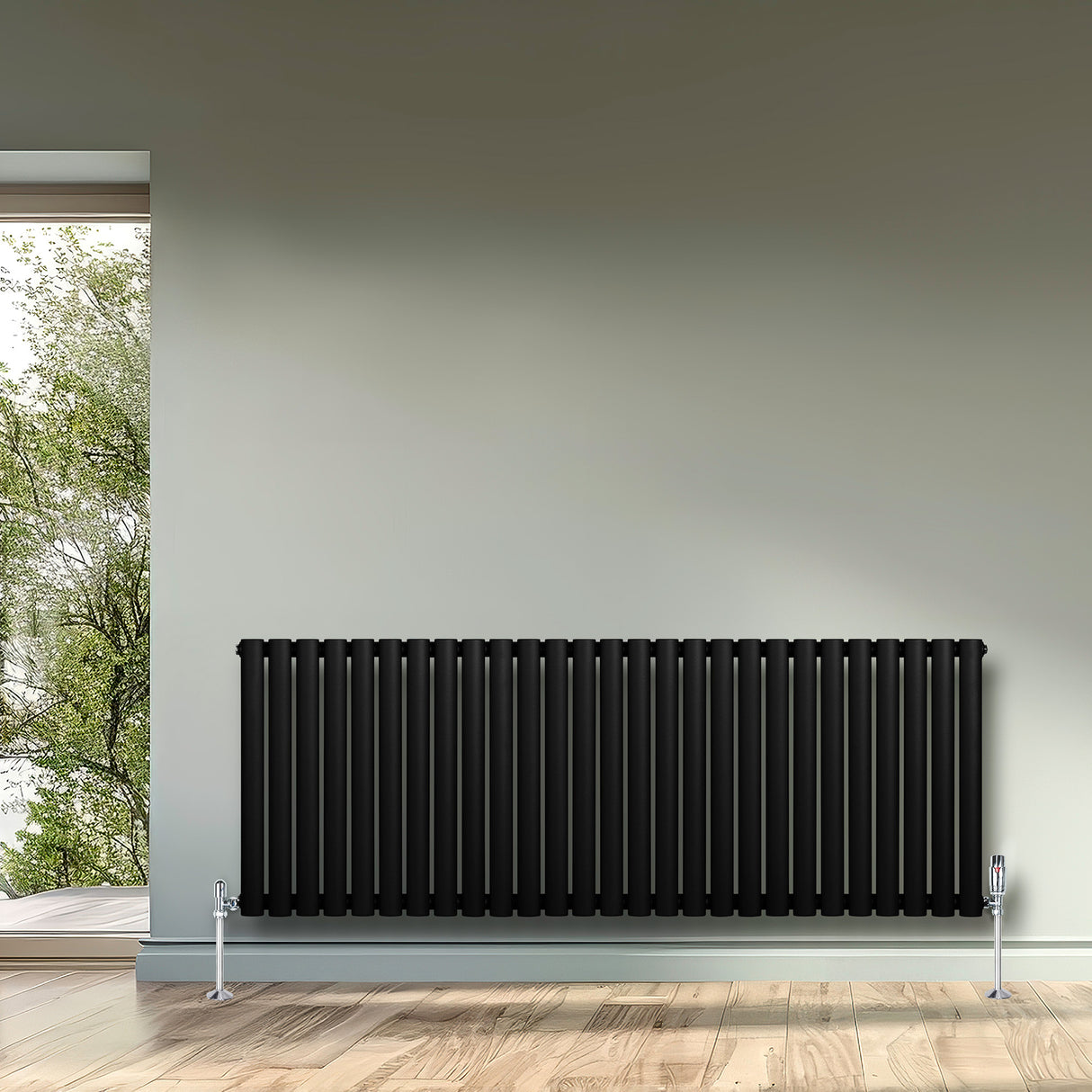 Schwarzer Gliederheizkörper mit TRV Chromventilen, 600mm x 1620mm, elegant und modern, platziert an einer Wand mit Fensterblick auf grüne Bäume
