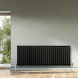 Schwarzer Gliederheizkörper mit TRV Chromventilen, 600mm x 1620mm, elegant und modern, platziert an einer Wand mit Fensterblick auf grüne Bäume