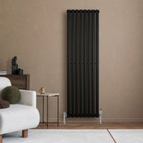 Schwarzer Gliederheizkörper mit TRV Chromventilen, 1600mm x 480mm, an einer neutralen Wand, umgeben von moderner Einrichtung und Möbeln