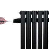 Schwarzer Gliederheizkörper mit TRV Chromventilen, 1600mm x 480mm, während einer Reinigung mit einer Bürste, glänzende Oberfläche und moderne Linienführung