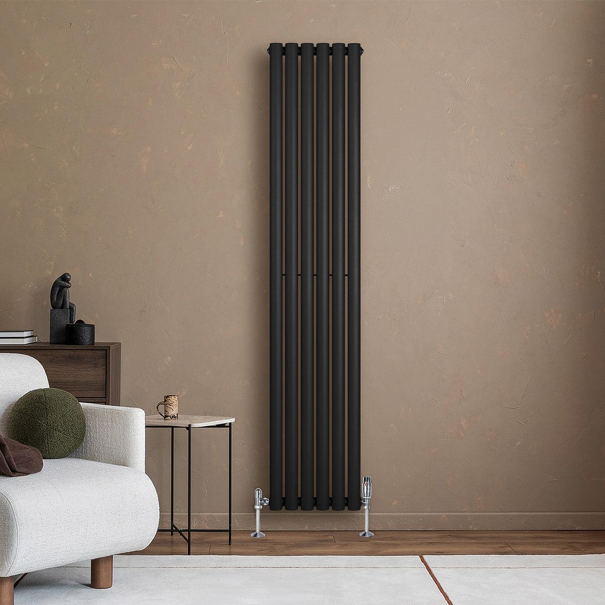 Schwarzer Gliederheizkörper mit TRV Chromventilen, 1800mm x 360mm, an einer Wand, umgeben von modernem Möbel und neutralen Farben