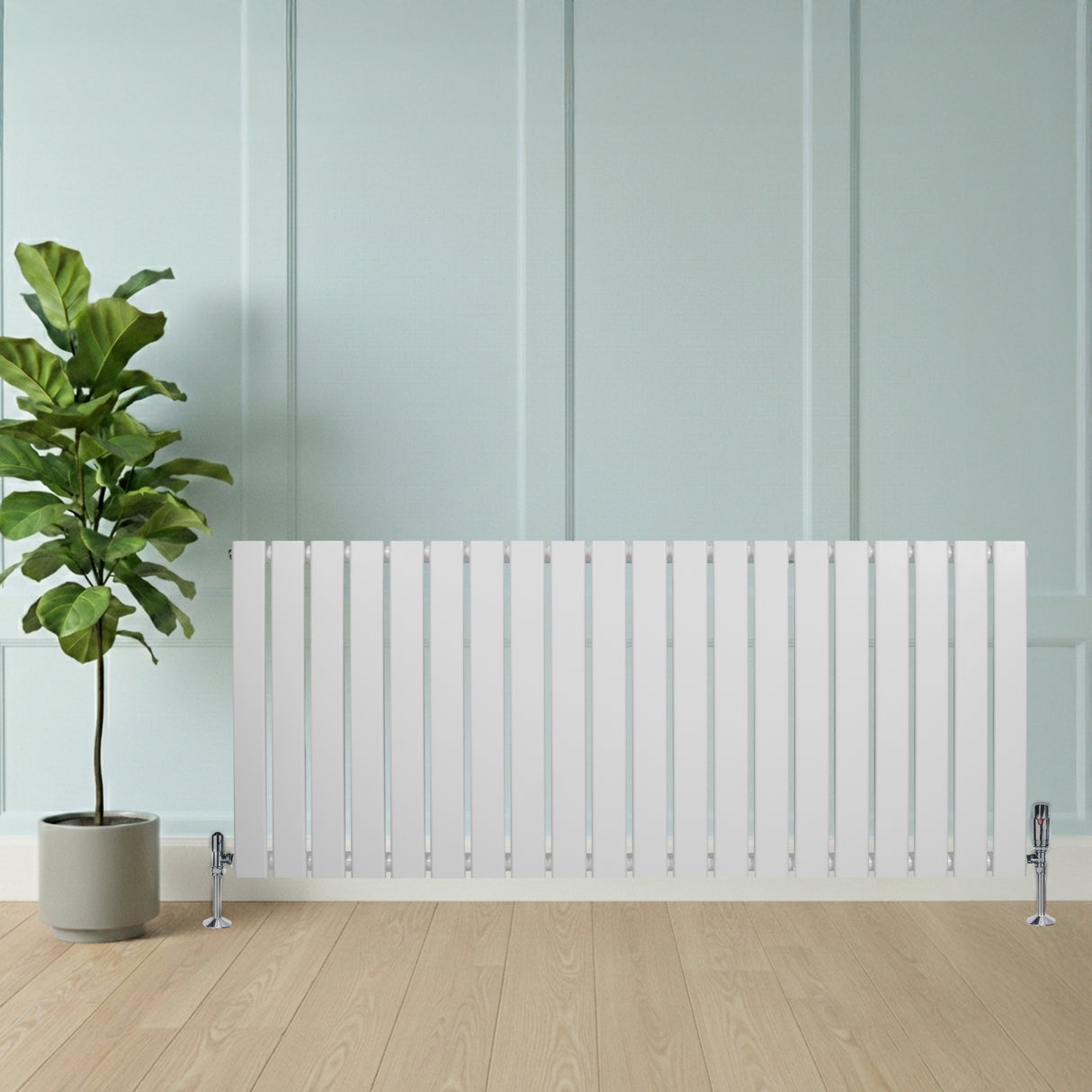 Flachheizkörper in Weiß, 600mm x 1400mm, mit vertikalen Lamellen und eleganten Ventilen, vor einer hellen Wand und einem Topf mit einer Pflanze