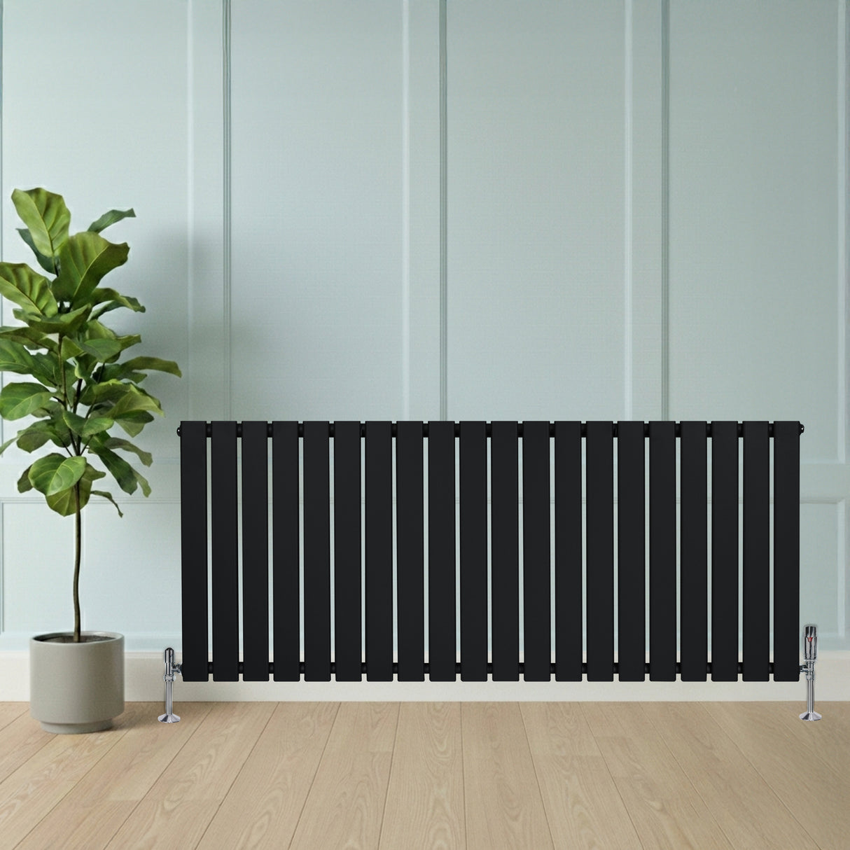 Schwarzer Flachheizkörper mit vertikalen Lamellen, 600mm x 1400mm, elegant vor einer Wand, neben einem Topf mit einer grünen Pflanze auf Holzboden