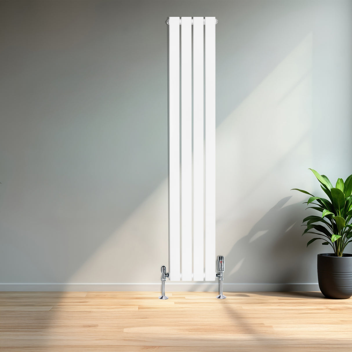 Flachheizkörper in Weiß, 1600mm x 280mm, mit glatten, vertikalen Lamellen und glänzenden Ventilen, vor einer hellen Wand und einem Pflanzenarrangement
