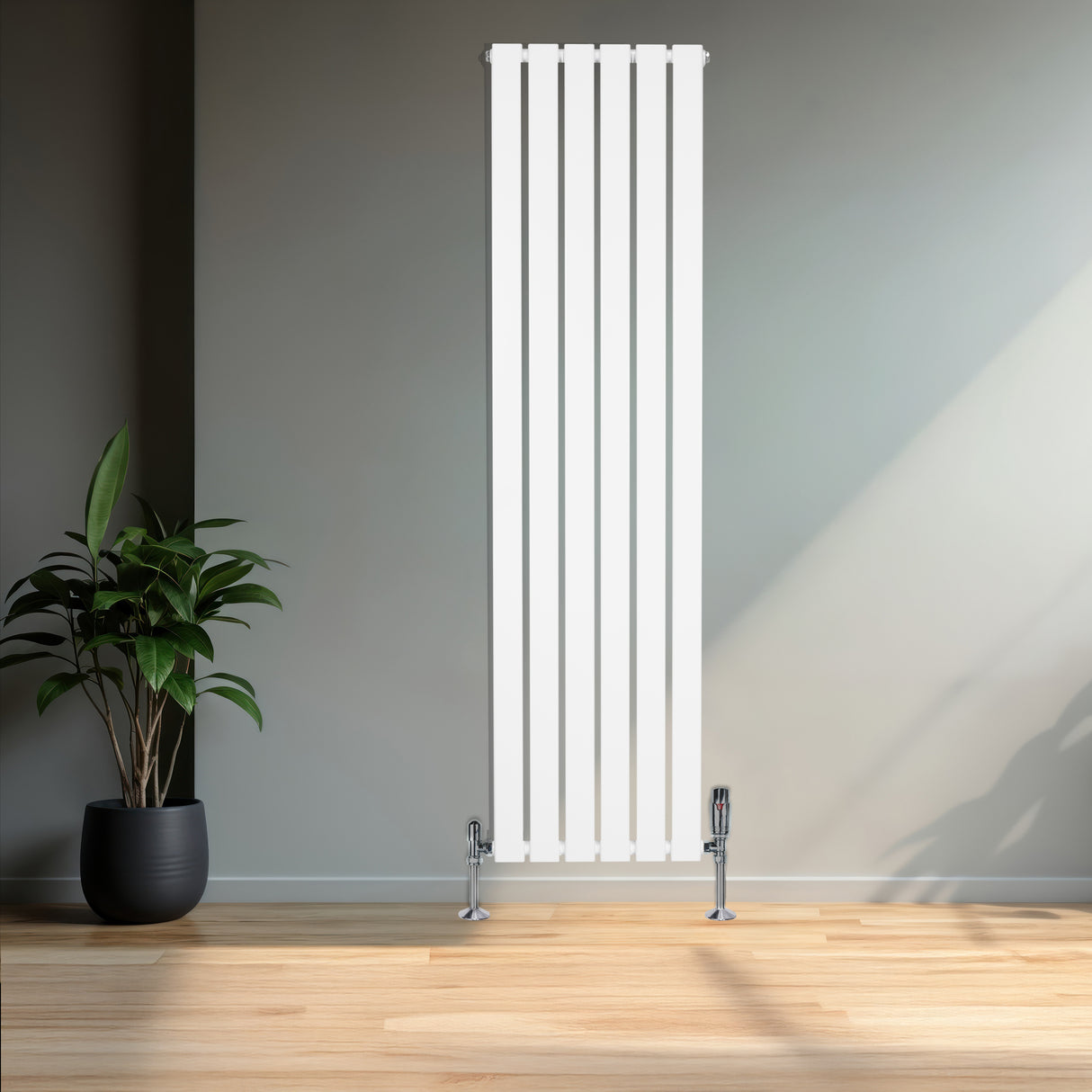 Flachheizkörper in Weiß, 1600mm x 420mm, mit vertikalen Lamellen und glänzenden Ventilen, steht vor einer grauen Wand, umgeben von einem modernen Raum
