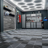 Sechseckige, belüftete Garagenbodenfliesen in Schwarz und Grau, mit Kantenschutz, auf einem modernen, strukturierten Boden in einer stilvollen Garage