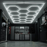 Sechseckige LED-beleuchtete Garagenbodenfliesen in Grau und Blau, mit Kantenschutz, auf einem modernen, glänzenden Boden in einer stilvollen Garage