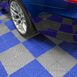 Belüftete Garagenbodenfliesen in Grau und Blau mit rutschfester Oberfläche, unter einem blauen Auto, das auf dem Muster steht