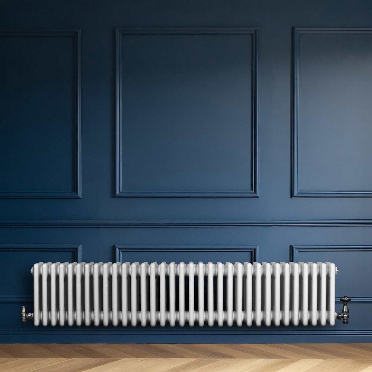 Röhrenheizkörper mit vier Säulen in Weiß, elegant und modern, montiert an einer blauen Wand, ergänzt durch einen hellen Holzboden