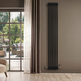 Schwarzer Röhrenheizkörper mit vier Säulen, 1800mm x 290mm, elegant an einer Wand montiert, umgeben von natürlichem Licht und modernen Möbeln