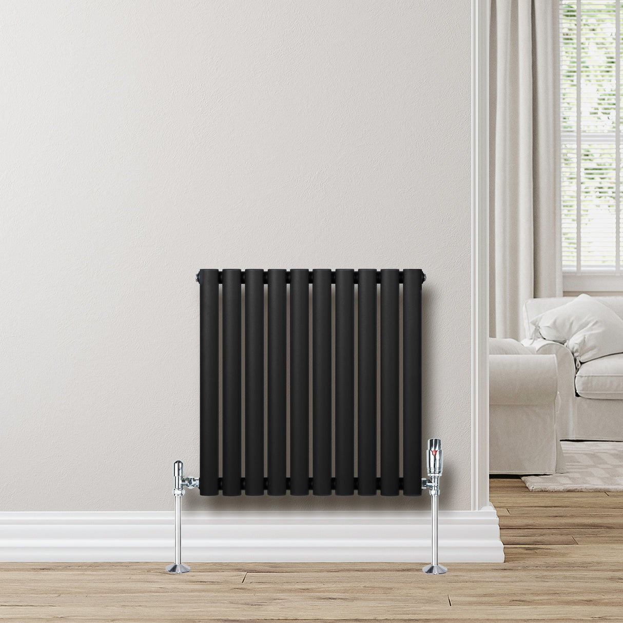 Schwarzer Gliederheizkörper mit 600mm x 600mm, vertikale Röhren, glänzende Ventile, elegant an einer hellen Wand montiert, umgeben von einem modernen Raum