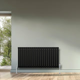 Schwarzer Gliederheizkörper mit 600mm x 1200mm, vertikalen Lamellen, glänzender Oberfläche und stabilen Füßen, ideal für moderne Innenräume