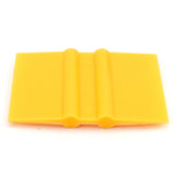 Gelber Rakel aus flexiblem Kunststoff mit glatter Oberfläche, ideal zum Entgittern von Vinylfolien und für präzise Anwendungen im Bastelbereich