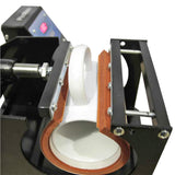 Tassenpresse mit schwarzem Gehäuse, rotem Silikonring und weißer Tasse, die zur Druckanwendung vorbereitet ist, zeigt präzise Drucktechnik