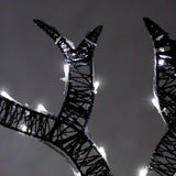 Schwarze, beleuchtete Rentiergeweihe mit weißen LED-Lichtern, die eine festliche Atmosphäre schaffen, ideal für Weihnachtsdekorationen